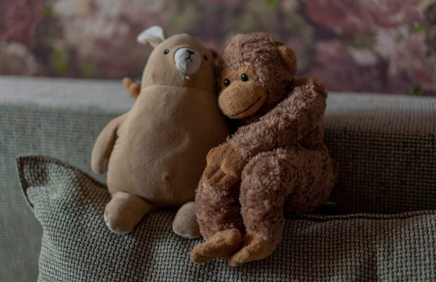 brown bear plush toy on brown textile