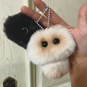 Mewmie, made of ultra-soft faux fur, with big expressive eyes and a clasp for attaching to bags or keys. Available in multiple colors.